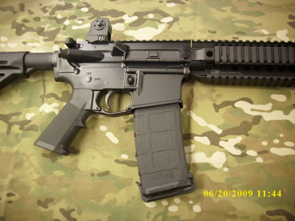 AR-style rifle receiver and magazine on camo